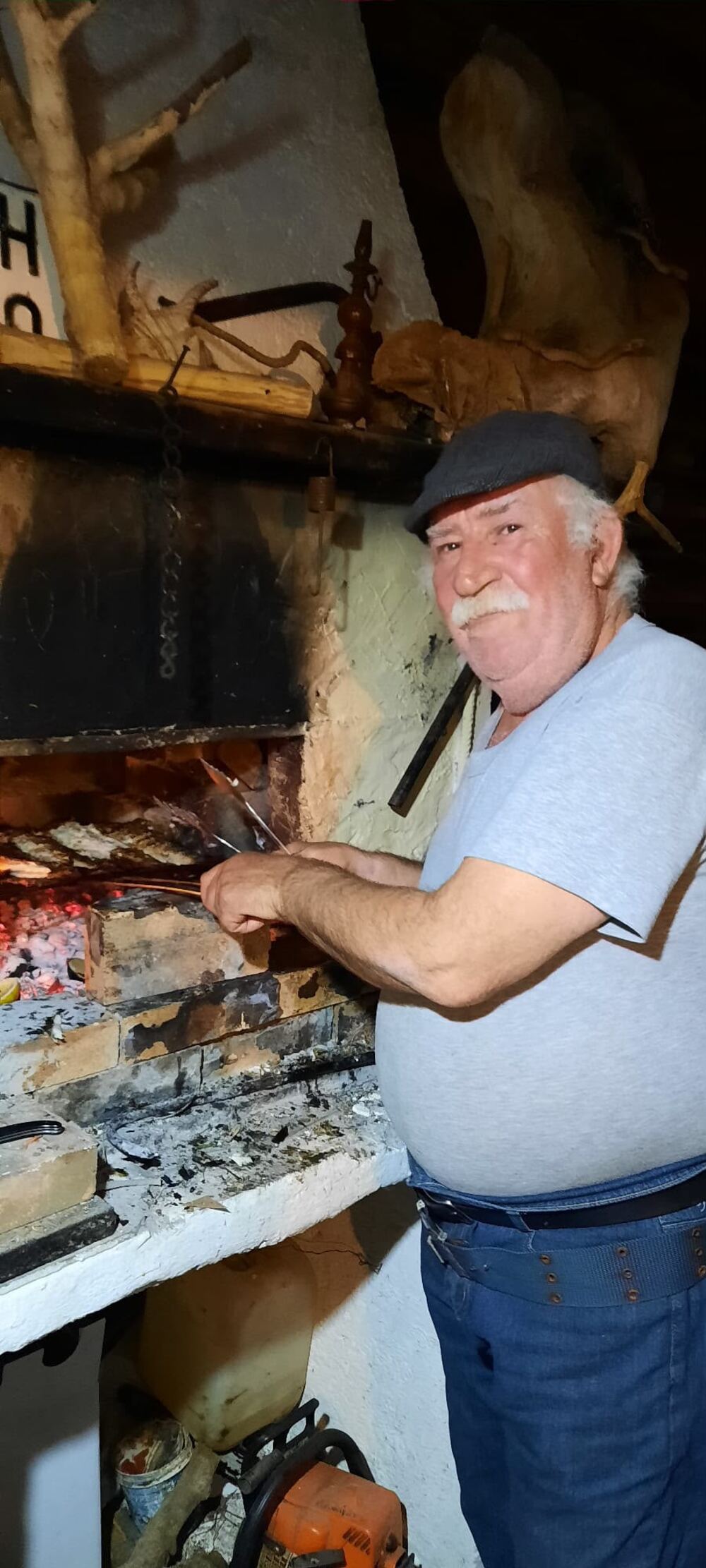 Dimitris grilling fresh fish over the wood fire
